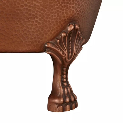 Close-up of a copper bathtub with intricate design on the leg.