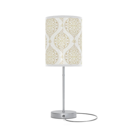 Table lamp with a decorative white and gold patterned shade on a white background