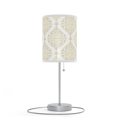 Table lamp with decorative white and gold patterned shade on a white background