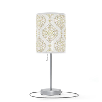 Table lamp with decorative white and gold patterned shade on a white background