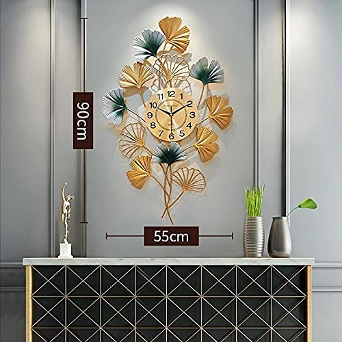 Decorative wall clock with leaf design on a gray wall