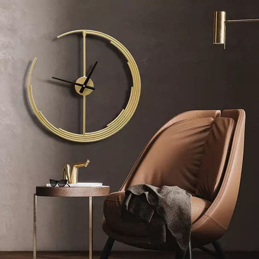 Modern interior with a gold wall clock, brown chair, and side table against a dark wall.