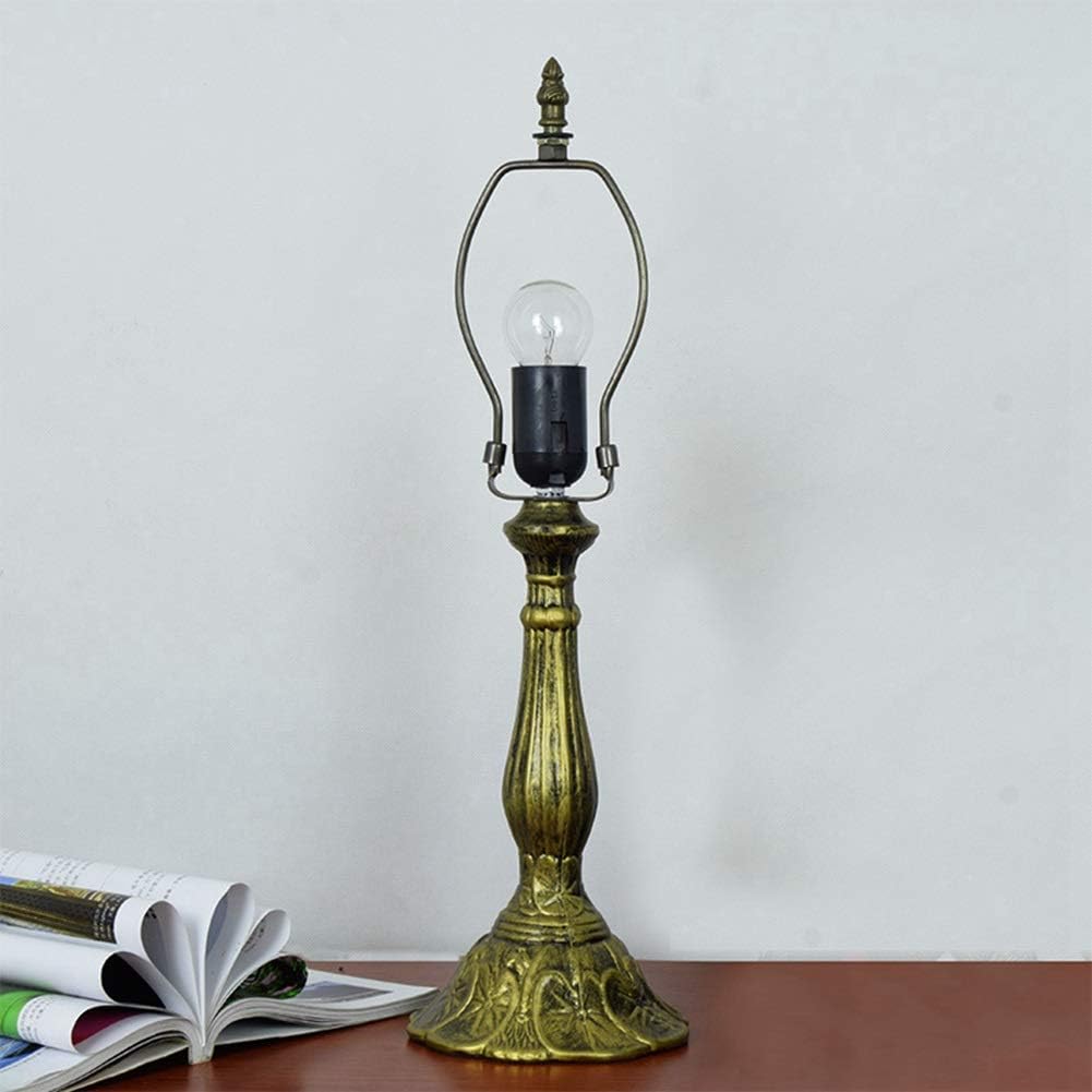 Vintage-style brass table lamp with a light bulb on a wooden surface.
