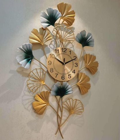 Decorative wall clock with leaf designs on a plain background