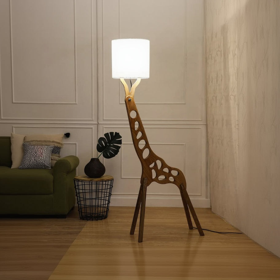 Giraffe-shaped floor lamp in a room with a green sofa and decorative items.