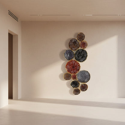 Decorative wall art with circular, textured elements in various colors on a light background