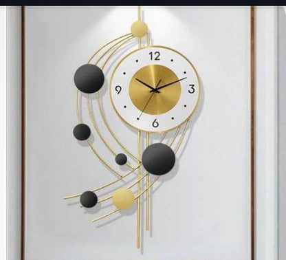 Decorative wall clock with gold and black design on a white background