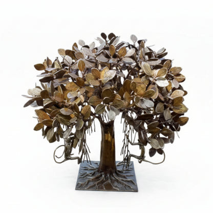 Decorative metal tree sculpture with leaves in gold, silver, and bronze on a white background