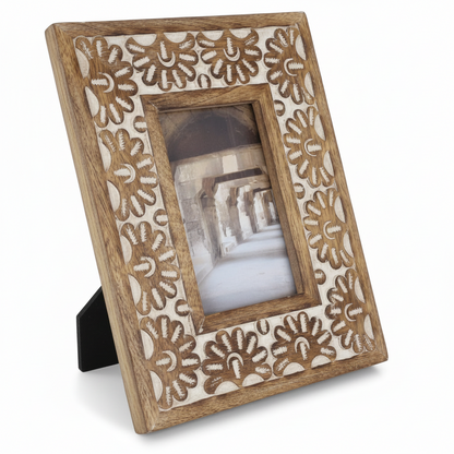Wooden photo frame with floral patterns on a white background