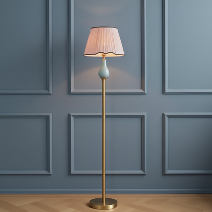 Floor lamp with a pleated shade against a paneled wall.