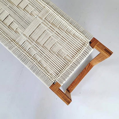 Woven stool with wooden legs on a white background