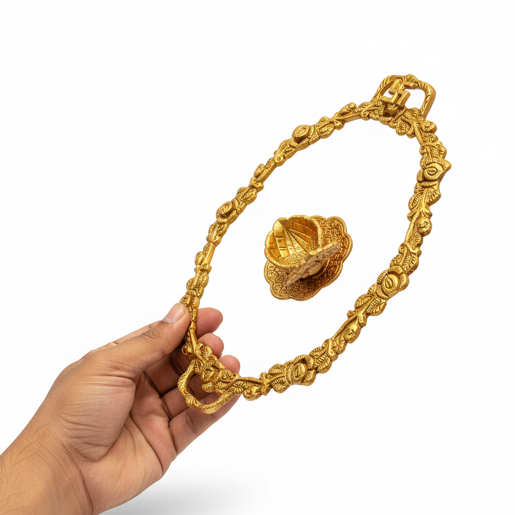 Gold necklace with intricate design held by a hand on a white background