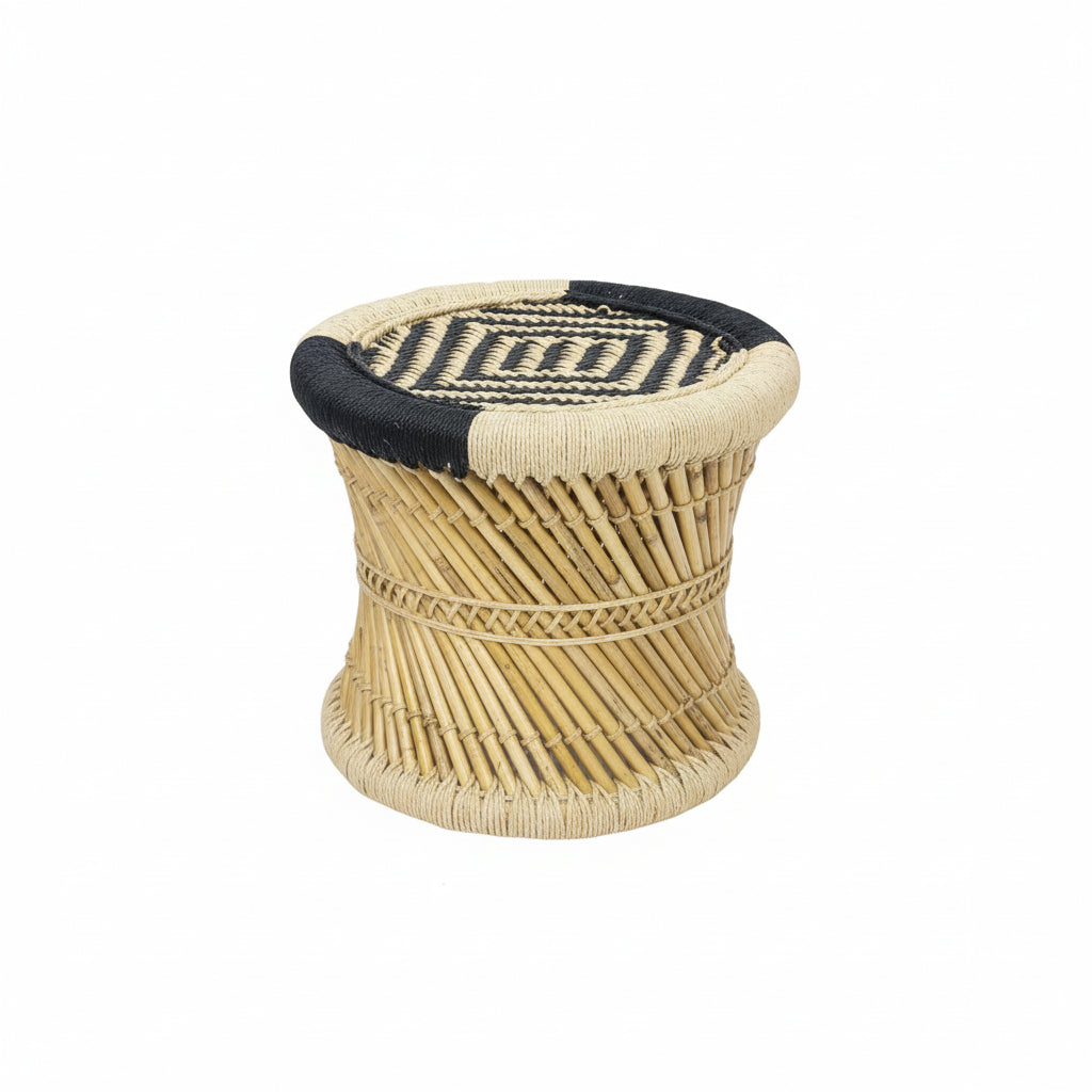 Woven stool with geometric pattern on a dark surface against an orange wall