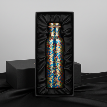 Decorative bottle with intricate patterns in a black gift box on a dark fabric background
