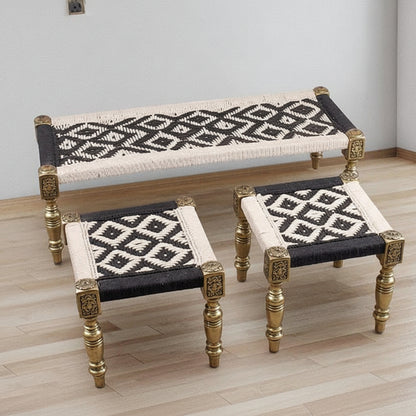 Set of three wooden stools with black and white patterned seats on a wooden floor.