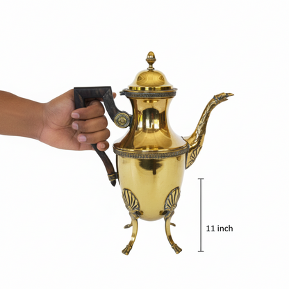 Gold teapot held by a hand with a measurement label indicating 11 inches on a white background