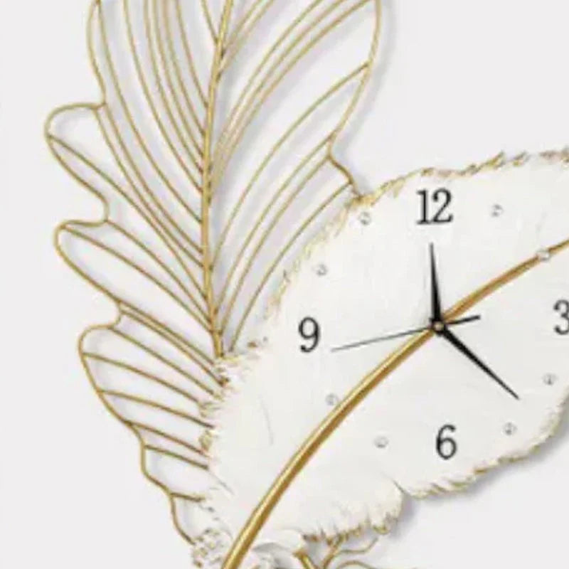 Decorative wall clock with gold leaf design on a white background