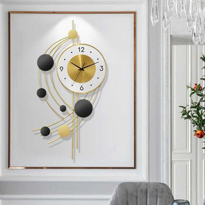 Decorative wall clock with gold and black design on a white wall.