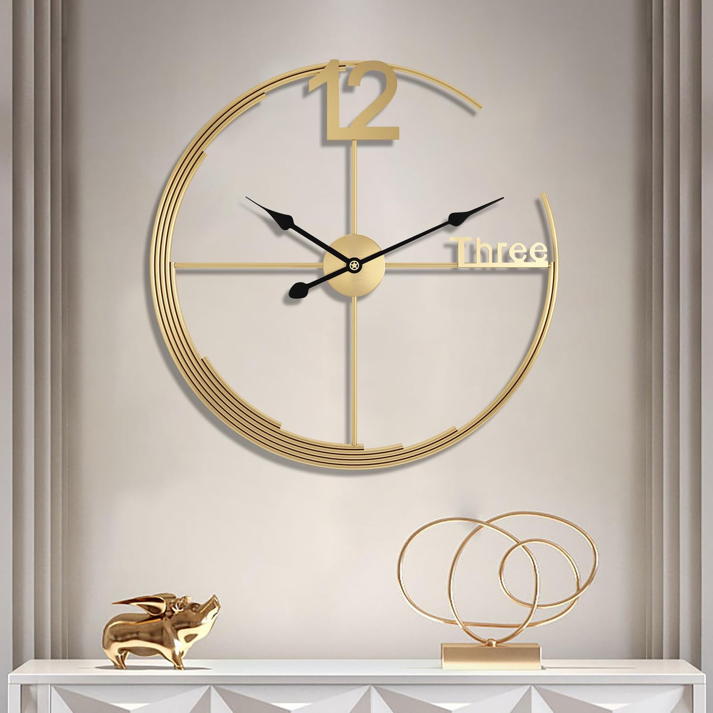 Gold wall clock on a neutral wall with decorative items below