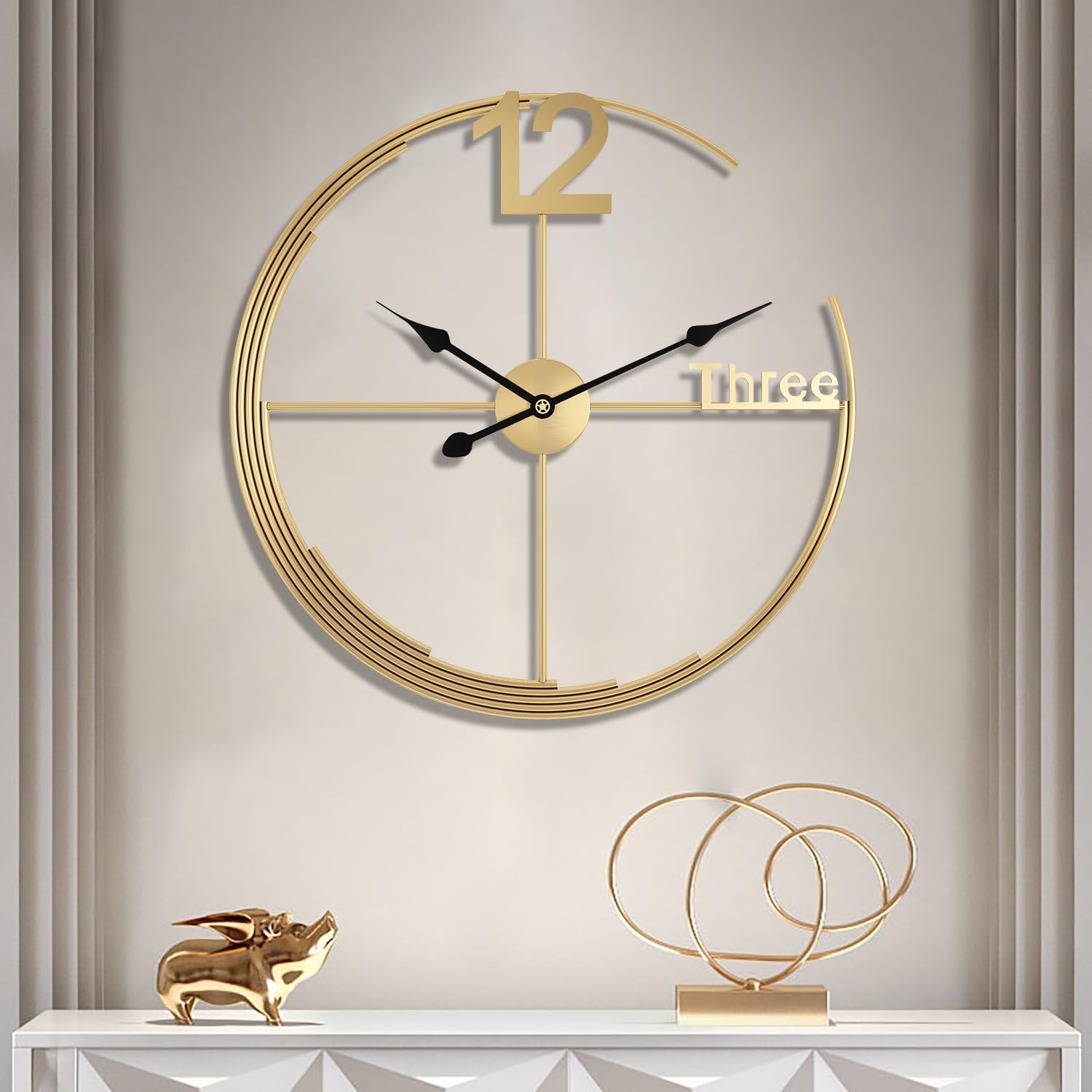 Gold wall clock on a neutral wall with decorative items below