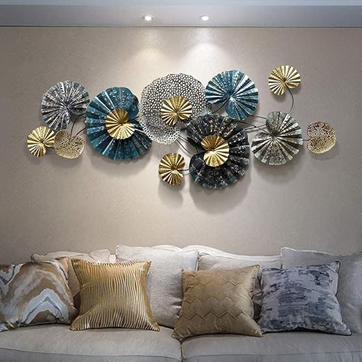 Decorative wall art with circular metal panels in various colors on a beige wall above a sofa.