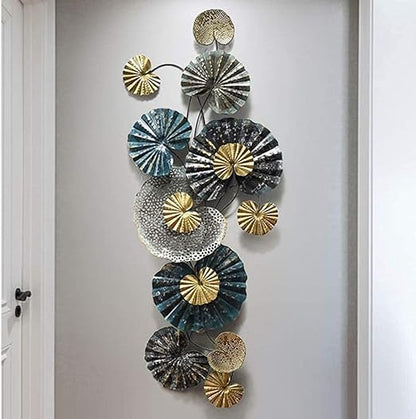 Decorative wall art with circular metal plates in gold, silver, and blue on a white wall.