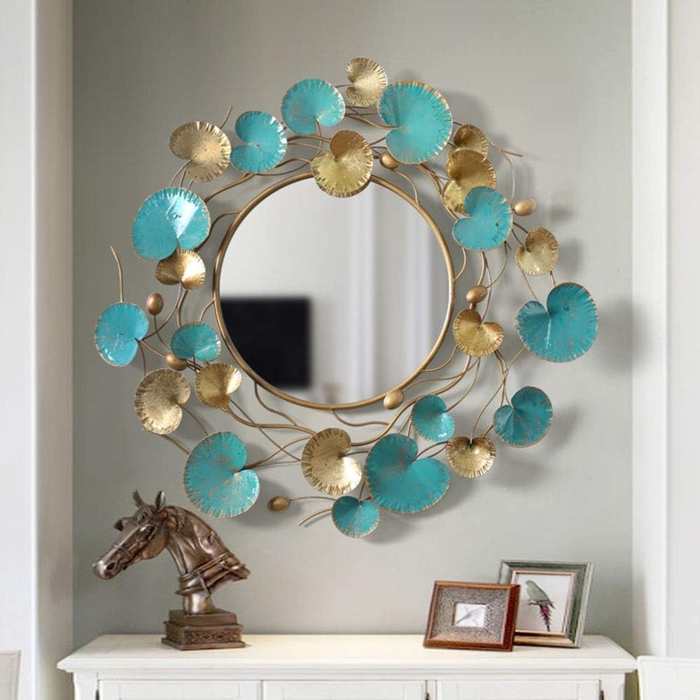 Decorative wall mirror with turquoise and gold leaf design on a gray wall.