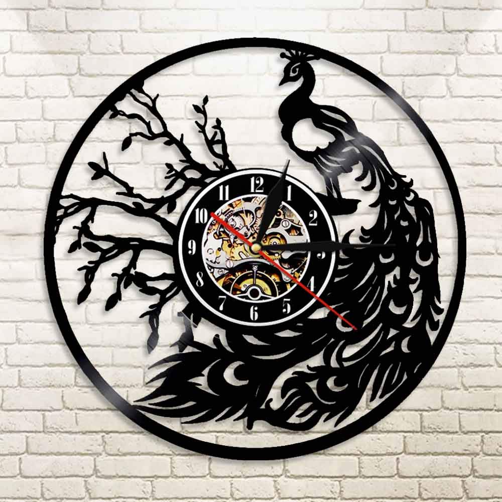 Decorative wall clock with peacock design on a brick wall background