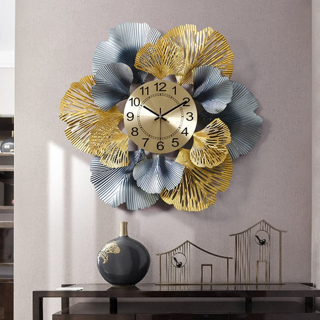 Decorative wall clock with gold and silver floral design on a wall.