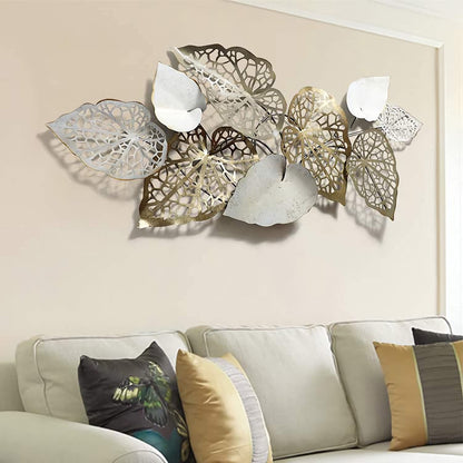 Decorative wall art with leaf patterns above a sofa with patterned cushions.