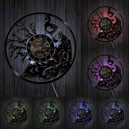 Decorative wall clock with peacock design and color-changing light effects on a wooden background.