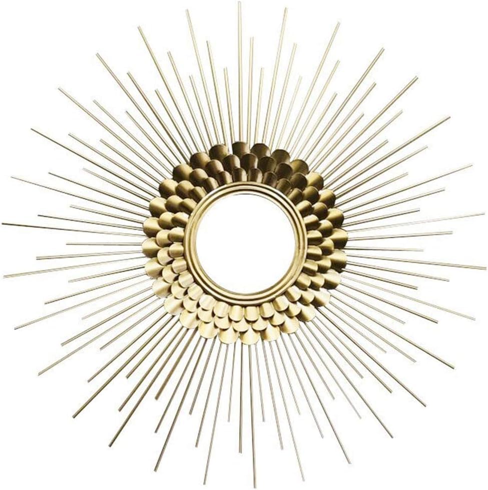 Decorative gold sunburst mirror on a white background