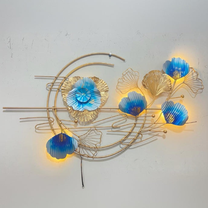 Decorative wall art with blue floral shapes and gold metalwork on a light gray background