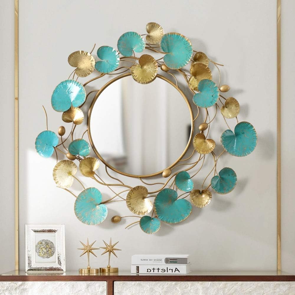 Decorative wall mirror with gold and turquoise accents on a neutral background