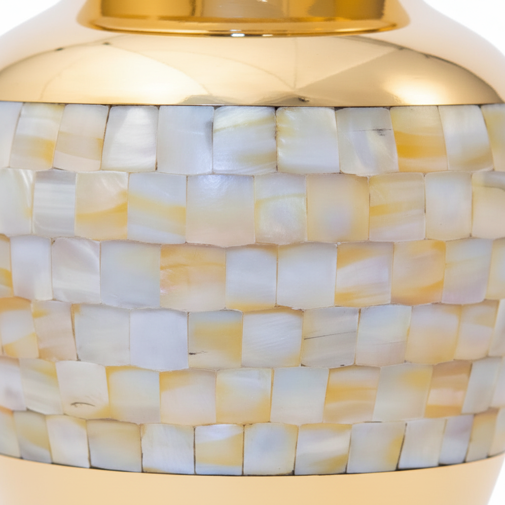 Close-up of a decorative vase with a gold top and shell-patterned body.