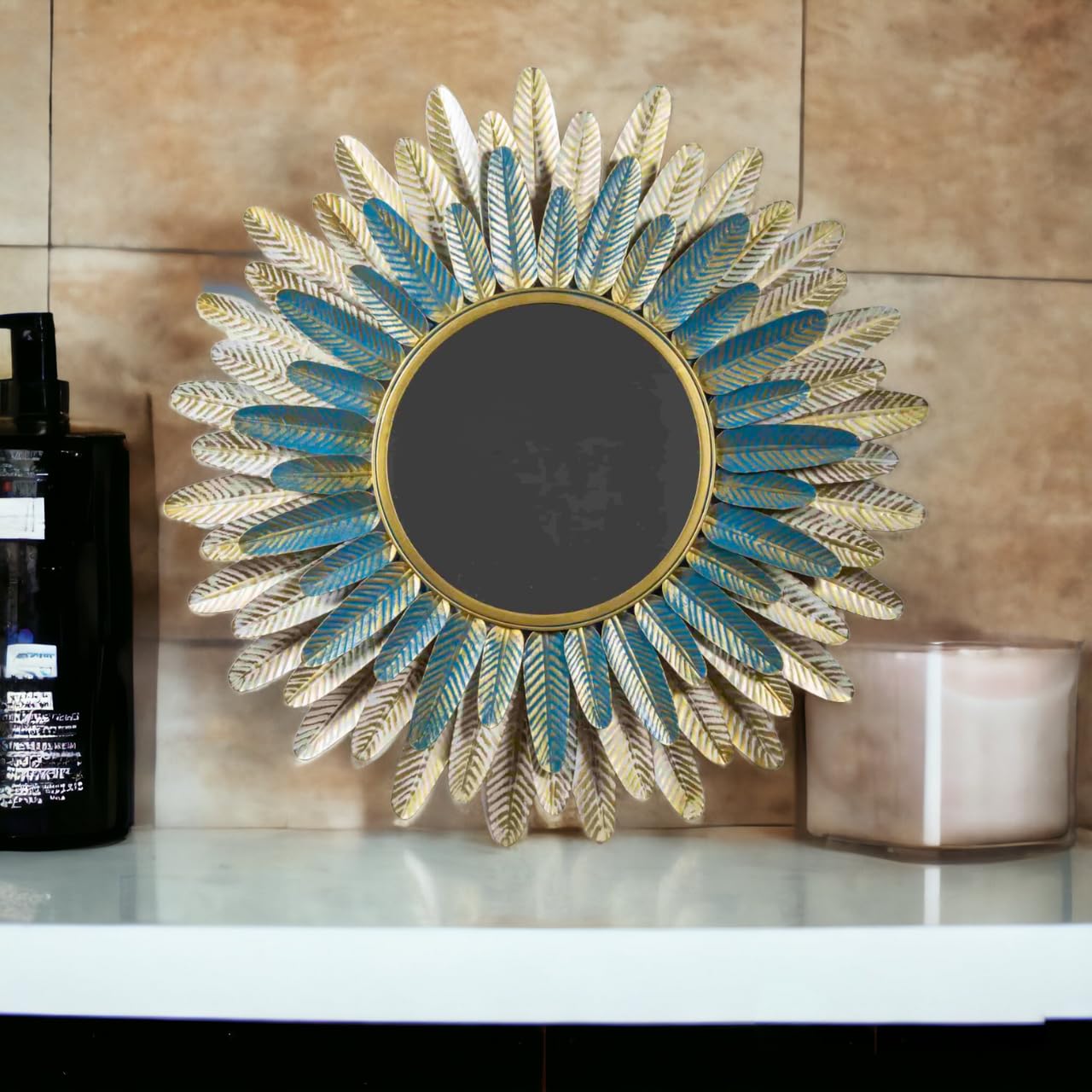 Decorative wall mirror with feather design on a shelf against a beige wall.