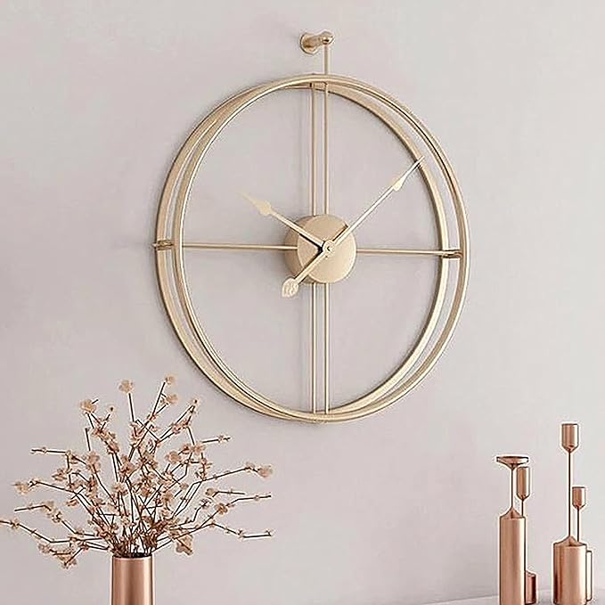 Gold wall clock on a light gray wall with decorative elements.
