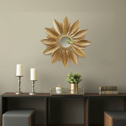 Decorative sunflower-shaped mirror on a wall above a wooden console table with candles and a plant.