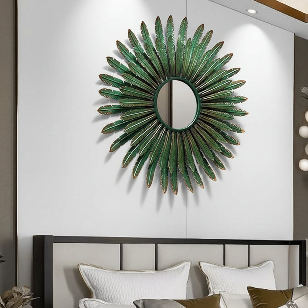 Decorative green wall mirror with feather-like design on a neutral wall above a bed.