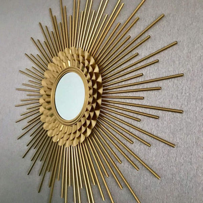 Decorative gold sunburst mirror on a plain wall