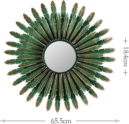 Decorative sunburst mirror with green leaf-like design on a white background