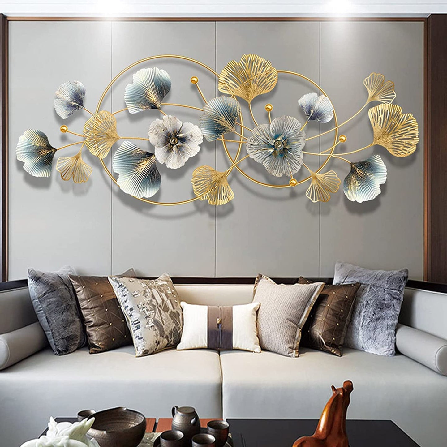Decorative wall art with flowers on a gray wall above a sofa with patterned cushions.