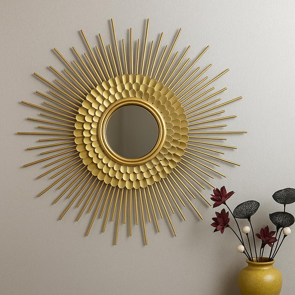 Gold sunburst mirror on a wall with a vase of flowers in the corner.
