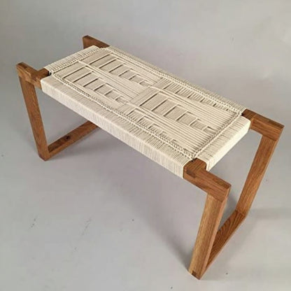 Wooden bench with woven seat on a plain background
