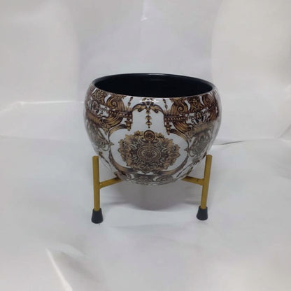 Decorative pot with intricate design on a stand against a white background