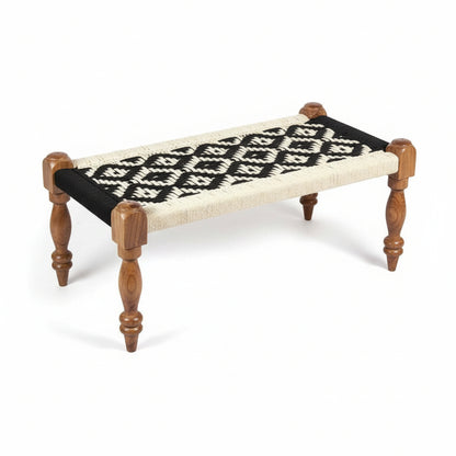 Small wooden bench with black and white patterned cushion on a white background