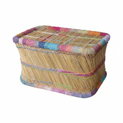 Woven basket with a colorful woven lid on a concrete floor.