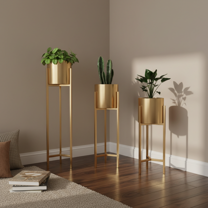 Three gold plant stands with potted plants against a neutral wall.