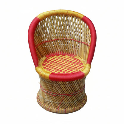 Woven chair with red and gold accents on a concrete floor.