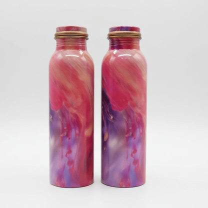Two marbled pink and purple bottles on a table.